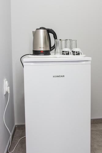 a tea kettle on top of a white refrigerator at Feher Akac Guest House in Palić