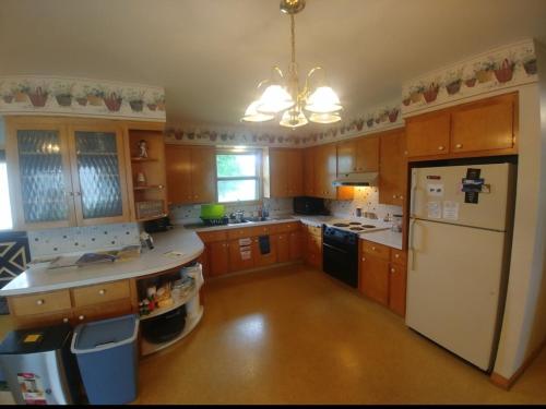 a kitchen with wooden cabinets and a white refrigerator at Brett's on the Lake in Durand