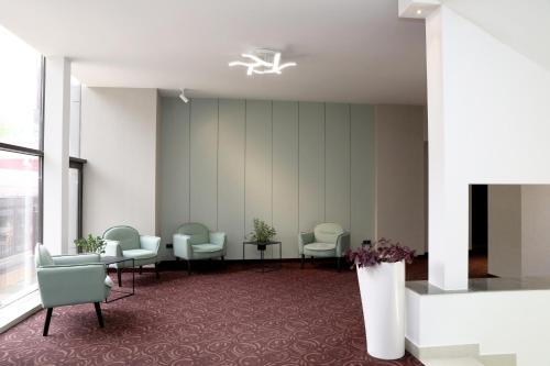 a waiting room with chairs and tables in a building at Best Western Plus Paradise Hotel Dilijan in Dilijan