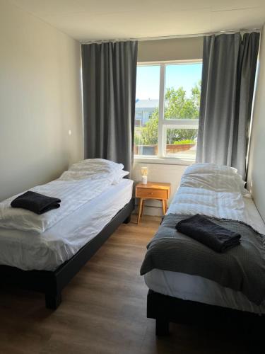 2 camas individuales en una habitación con ventana en Stykkishólmur house, en Stykkishólmur