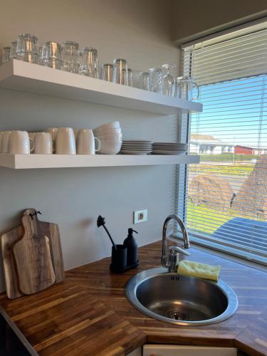 eine Küchentheke mit einem Waschbecken und einem Fenster in der Unterkunft Stykkishólmur house in Stykkishólmur