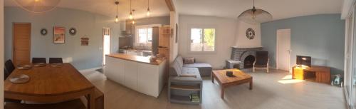 sala de estar con cocina y sala de estar con mesa en maison landaise à proximité de la plage et centre en Biscarrosse-Plage