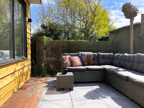 a couch sitting on a patio next to a fence at Het Zonnetje in Wijk aan Zee