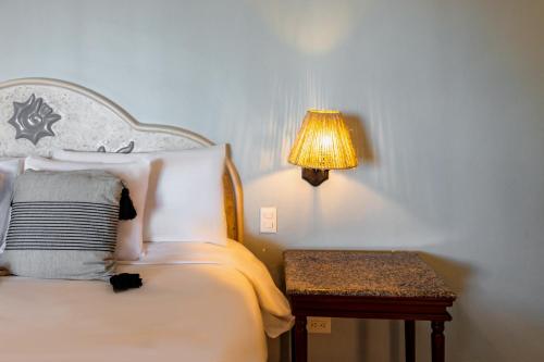 a bedroom with a bed with a lamp and a table at Reef Yucatán All Inclusive & Convention Center in Telchac Puerto