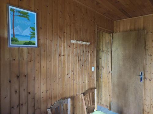 a room with wooden walls and a picture on the wall at Bel appartement au rez de chaussée d'un chalet in Jarrier