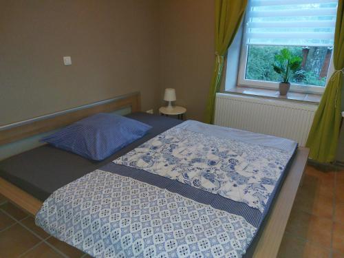 sypialnia z łóżkiem z niebiesko-białym kocem w obiekcie Koralle w mieście Boltenhagen