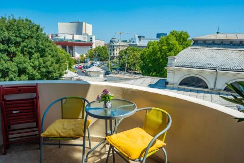 - Balcón con mesa pequeña y 2 sillas en CNC Apartments, en Bucarest