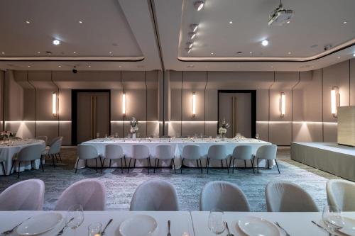 a banquet hall with white tables and chairs at Mii Hotel Srinakarin in Bangna