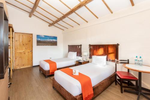a hotel room with two beds and a table at Casa Andina Standard Colca in Chivay