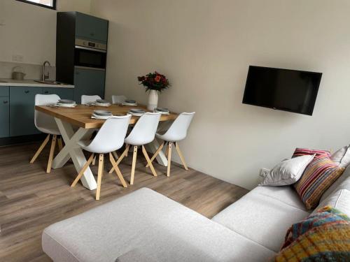 een woonkamer met een tafel en witte stoelen bij Het Zonnetje in Wijk aan Zee
