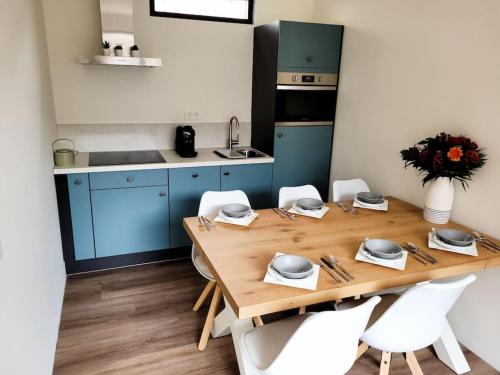 a kitchen with a wooden table and white chairs at Het Zonnetje in Wijk aan Zee