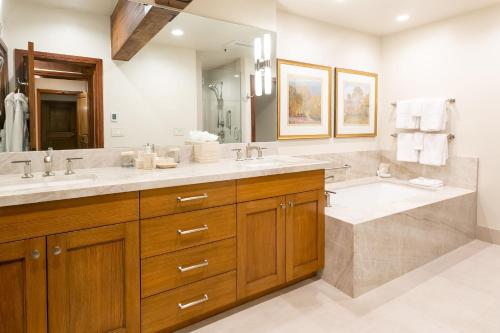 a bathroom with two sinks and a large mirror at Deluxe King Room with Fireplace Hotel Room in Park City