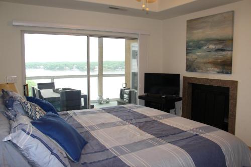 a bedroom with a bed with a fireplace and a large window at Lake Ozarks Get Away Topsider in Lake Ozark