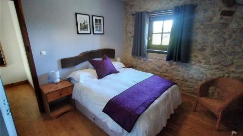 um quarto com uma cama e uma janela em Character 2 bed cottage within walking distance of bar/restaurants em Piégut-Pluviers