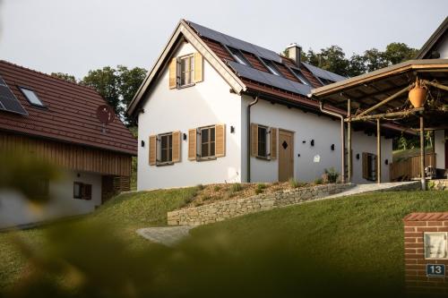 una casa blanca con paneles solares en el techo en WIENER Kellerstöckl - Das 11er, en Eltendorf