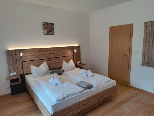 a bedroom with a large bed with white sheets and pillows at Ferien vom Ich, Bayerischer Wald, Hotel & Restaurant in Neukirchen