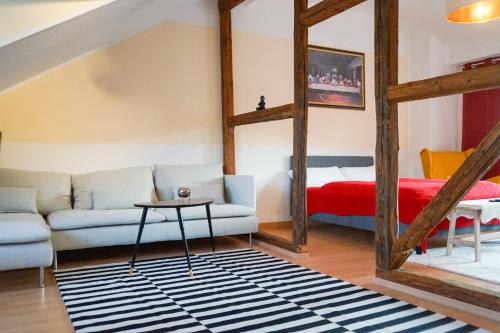 a living room with a couch and a bed at FULL HOUSE Premium Apartments Jena Holzmarkt in Jena