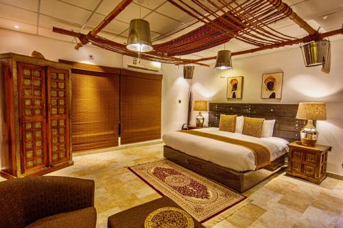 a bedroom with a bed and a chair in a room at Coastline Resort in Al-Musannah