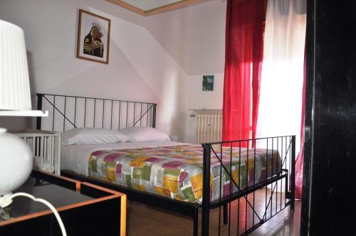 um quarto com uma cama e uma cortina vermelha em VIALE REPUBBLICA 329 9 em Pietra Ligure