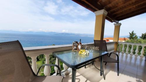 uma mesa e cadeiras numa varanda com o oceano em Vasilakis Home Fantasy Balcony Apraos em Apraos