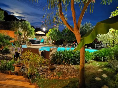 a swimming pool in a garden at night at B&B Lou Mas in Pommeret