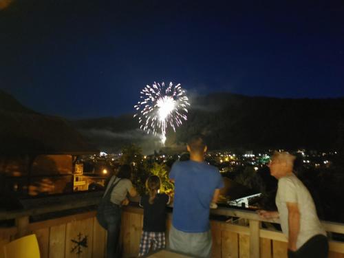 a group of people standing on a fence watching fireworks at Résidence Julianna , trajets remontées mécaniques , livraison viennoiseries, piscine couverte in Morzine