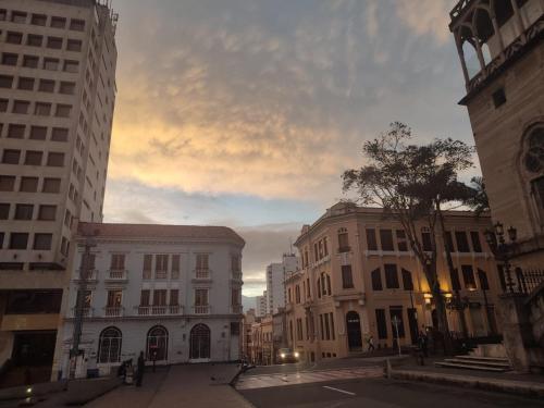 HOTEL LA REPUBLICA MANIZALES في مانيزاليس: شارع المدينة فيه مباني وسماء غائمة
