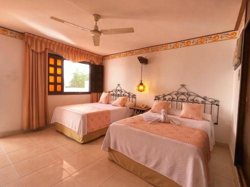 a bedroom with two beds and a window at Hotel Zaci in Valladolid