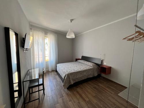 um quarto com uma cama, uma mesa e uma janela em We Love Tower Self Check-In em Pisa