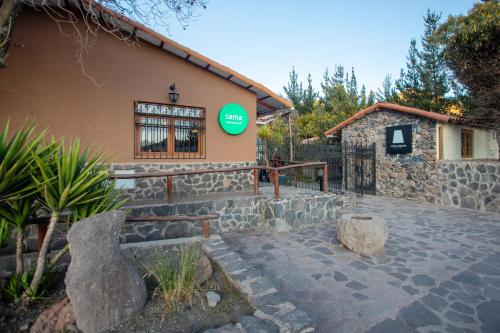 a building with a green sign on the side of it at Casa Andina Standard Colca in Chivay