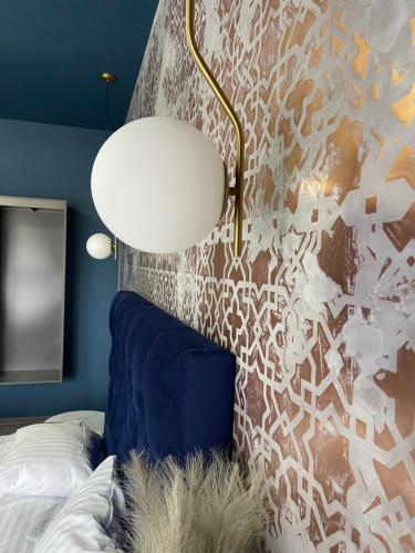 a bedroom with a bed and a lamp and a wall at Pensiunea Casa Buna in Gîrbova
