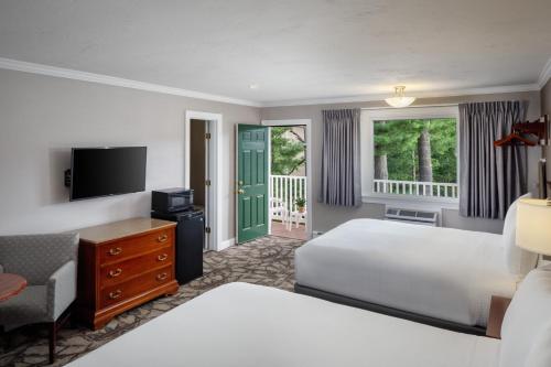 a hotel room with two beds and a television at Golden Gables Inn in North Conway