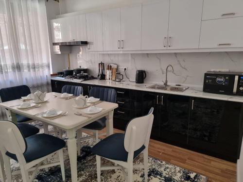 eine Küche mit einem weißen Tisch und Stühlen sowie einer Theke in der Unterkunft Квартира в аренду Tashkent in Taschkent