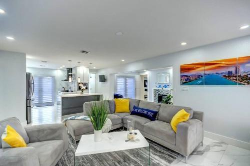 ein Wohnzimmer mit einem grauen Sofa und gelben Kissen in der Unterkunft Miami House with Hot Pool-spa & Pool table L48 in Hialeah