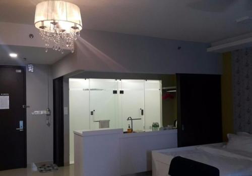 a bedroom with a large mirror and a bed and a chandelier at De Houz @ Setia Alam Trefoil Homestay in Shah Alam