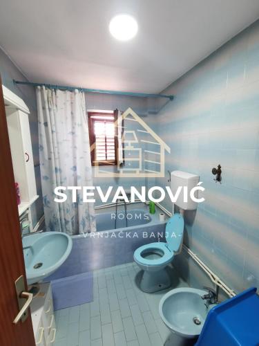 VrnjciにあるStevanovic Smestajのバスルーム(洗面台2台、トイレ付)、窓が備わります。