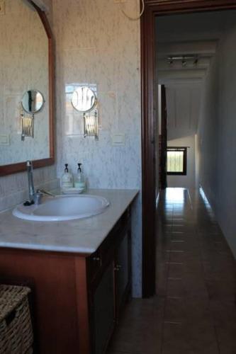a bathroom with a sink and a mirror and a hallway at Tita in Albir