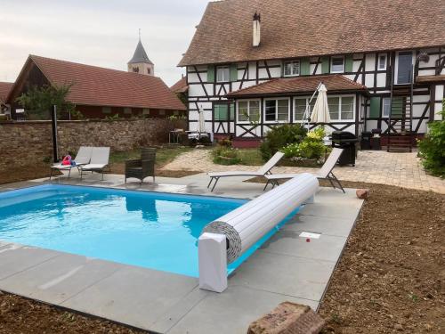 Fessenheim-le-BasにあるLa Ferme de Madeleineの家の前の滑り台付きプール