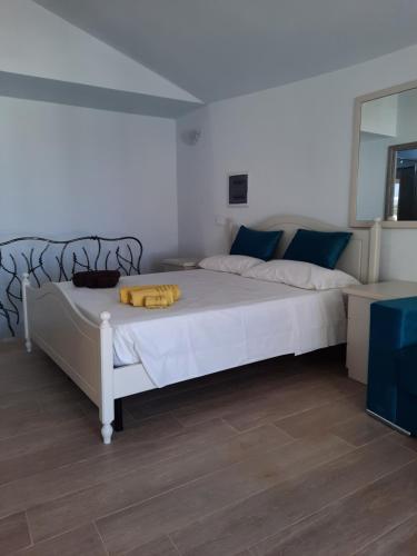 ein Schlafzimmer mit einem großen weißen Bett mit blauen Kissen in der Unterkunft Relax al Mare in Olbia