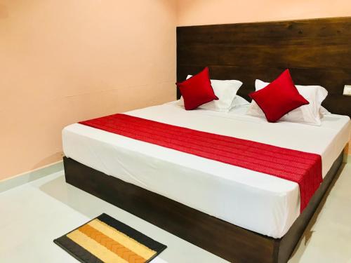 una camera da letto con un grande letto con cuscini rossi di Beach Bungalow Yala a Kirinda