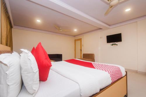 a bedroom with a bed with red and white pillows at Hotel Orbit Inn Near Infiniti Mall in Mumbai