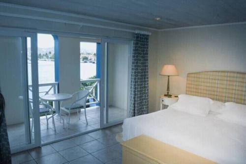 a bedroom with a bed and a balcony with a table at The Bliss in Gros Islet