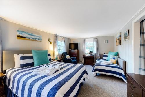 - une chambre avec 2 lits à rayures bleues et blanches dans l'établissement SeaWind Guest Studio, à Nauset Heights