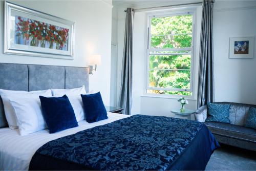 a bedroom with a bed and a window and a couch at Gresham Court in Torquay