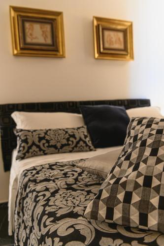 a bed with black and white sheets and pillows at Hotel CineApollo - Ogni camera un film! in Messina