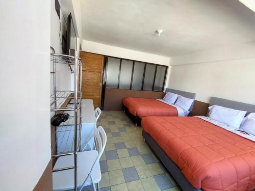 Habitación de hotel con 2 camas y escritorio en Las Dalias, en Cusco