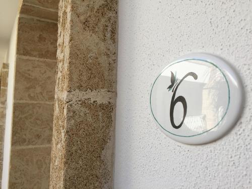 uma placa na parede com um número nela em Tenuta Aletheia B&B em Alliste