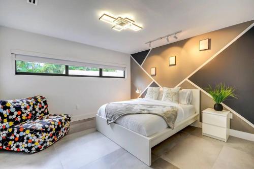 a bedroom with a white bed and a chair at Stylish Haven Heated Pool Pool Table L28 in Cutler Bay