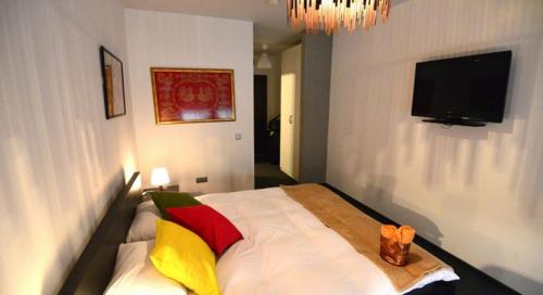a bedroom with a bed with colorful pillows on it at Hotel Biscuit in Cluj-Napoca