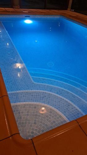 a large blue swimming pool with a chair next to it at Casa sol y montaña in Cubaba